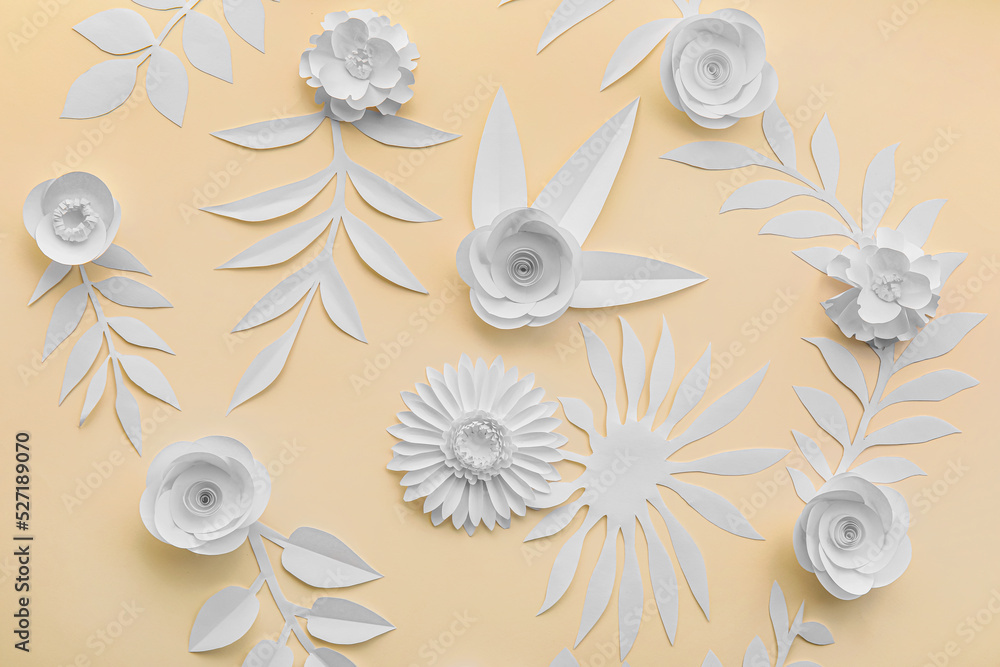 Paper flowers with leaves on beige background