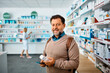 © Drazen - Male customer shopping in pharmacy and looking at camera.