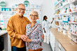 © Drazen - Portrait of happy senior couple in pharmacy looking at camera.