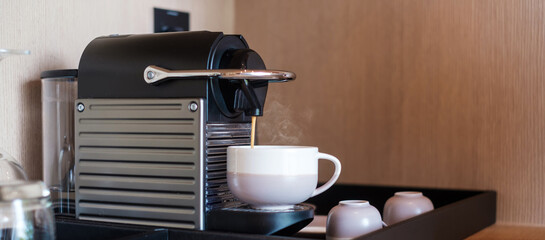 Hand making Espresso by Coffee Machine with capsules on wood table