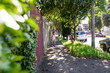 © Austockphoto - Smiling girl with helmet and roller skates on the side walks with cars, trees, grass and hedge