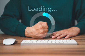 man using a computer keyboard to download and waiting to loading digital business data form website,
