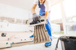 © andrew_shots - Repairman in grey gloves and special uniform laying cement on tile in a new house