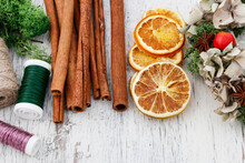 Cinnamon Sticks, Dried Oranges And Christmas Wreath On White Wooden Table.