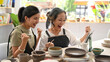 © Prathankarnpap - Happy young woman and middle aged woman creating handicraft crockery in workshop. Activity, handicraft, hobbies concept