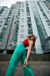 © chika_milan - A teenage girl is posing on the street surrounded by buildings.