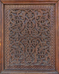 Closeup view of beautiful traditional wood carving on ancient door with intricate floral and geometric design, Istaravshan, Sughd region, Tajikistan