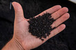 Recycled rubber in hand. Rubber crumb obtained in the process of recycling used car tires used for flooring sports and playgrounds.
