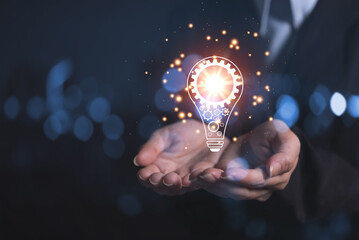 Fototapete - business woman's hand holding a light bulb driven by multiple gears inside, collaborating to find new ideas