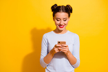 Wall Mural - Photo of adorable sweet girl dressed white shirt typing modern device empty space isolated yellow color background