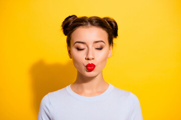 Wall Mural - Portrait of adorable female kissing her boyfriend with close eyes isolated on yellow color background