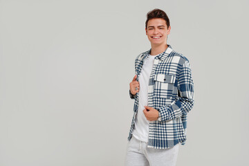 Wall Mural - Handsome young happy man posing in  fashionable shirt, smiling and looking at the camera. Student. Studio shot. Grey background.