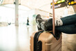 © ADDICTIVE STOCK - Crop female traveler holding legs on suitcase