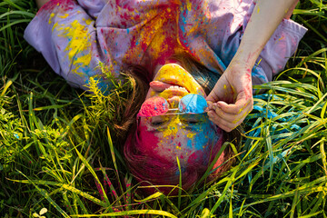 Woman covered holi powder in park. Holi colours festival.