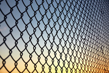 Chain Link Fence Against Sky At Sunset