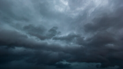 The dark sky with heavy clouds converging and a violent storm before the rain.Bad or moody weather sky and environment. carbon dioxide emissions, greenhouse effect, global warming, climate change.