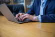 © Media Lens King - Closeup of the hands of a businessman typing on his laptop keyboard with copy space underneath.
