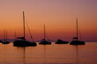 Several yachts standing in the bay against the sky during sunrise.