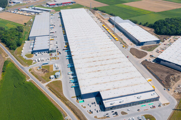 Wall Mural - Aerial view of a warehouse of goods. Logistic warehouse buildings and many trucks loading goods