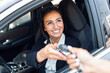 © nenetus - Car rental agency employee giving car keys to beautiful young woman.