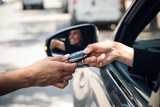 Fototapeta  - Car rental agency employee giving car keys to beautiful young woman.