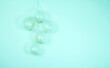 A monochromatic green confetti clear balloons against a light pink backdrop