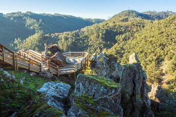 Wall Mural - Viewpoint of the walkways of Fragas de São Simão with rock formation in the foreground and the village of Casal de São Simão in the background, near Figueiró dos Vinhos in Portugal.