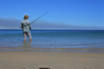 Wall Mural - Australian man fishing on a remote beach