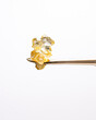 Saucey live resin diamonds on a gold titanium dab tool with a white background