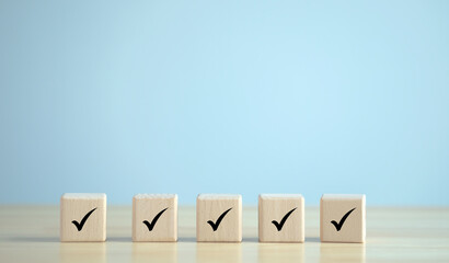 Checklist, Task list, Survey and assessment. Quality Control, confirm, accept, validation, Goals achievement and business success. Check mark icon on wooden blocks.