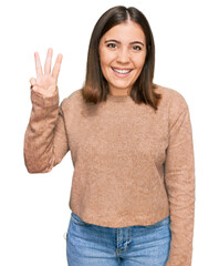 Poster - Young beautiful woman wearing casual clothes showing and pointing up with fingers number three while smiling confident and happy.