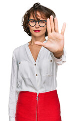 Canvas Print - Young hispanic woman wearing business style and glasses doing stop sing with palm of the hand. warning expression with negative and serious gesture on the face.