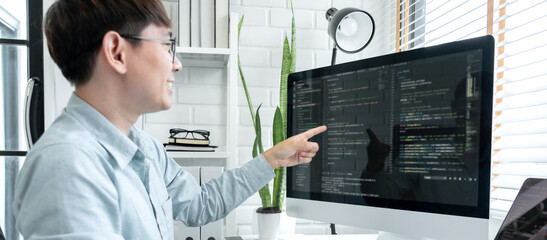 Male programmer pointing on screen and programing to developing program app and website of corporate