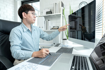 Male programmer pointing on screen and programing to developing program app and website of corporate