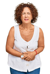 Wall Mural - Beautiful middle age mature woman wearing casual white shirt with hand on stomach because nausea, painful disease feeling unwell. ache concept.