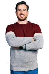 Wall Mural - Young hispanic man wearing casual clothes happy face smiling with crossed arms looking at the camera. positive person.