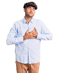 Sticker - Young hispanic man wearing casual shirt smiling with hands on chest with closed eyes and grateful gesture on face. health concept.