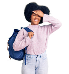 Poster - Young african american girl holding student backpack stressed and frustrated with hand on head, surprised and angry face