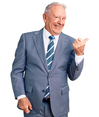 Canvas Print - Senior handsome grey-haired man wearing elegant suit smiling with happy face looking and pointing to the side with thumb up.