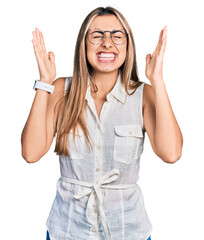 Sticker - Hispanic young woman wearing casual white shirt celebrating mad and crazy for success with arms raised and closed eyes screaming excited. winner concept