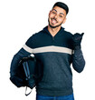 © Krakenimages.com - Young hispanic man with beard holding motorcycle helmet pointing thumb up to the side smiling happy with open mouth