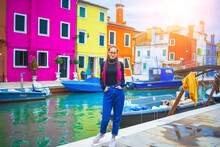 Happy Traveler Woman Having Fun Near Colorful Houses On Burano Island In Venetian Lagoon. Travel And Vacation In Italy Concept. Lifestyle Travel Moments In The Beautiful Italian City.