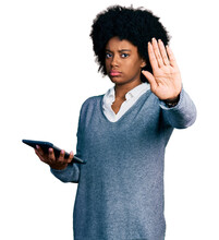 Young African American Woman Using Touchpad Device With Open Hand Doing Stop Sign With Serious And Confident Expression, Defense Gesture