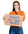 © Krakenimages.com - Young hispanic girl holding power to the people banner covering mouth with hand, shocked and afraid for mistake. surprised expression