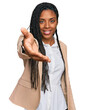 © Krakenimages.com - African american woman wearing business jacket smiling friendly offering handshake as greeting and welcoming. successful business.