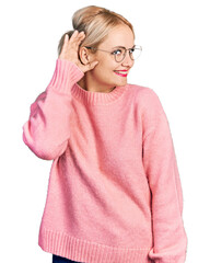 Canvas Print - Young blonde woman wearing casual clothes and glasses smiling with hand over ear listening an hearing to rumor or gossip. deafness concept.