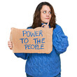 © Krakenimages.com - Young plus size woman holding power to the people banner serious face thinking about question with hand on chin, thoughtful about confusing idea
