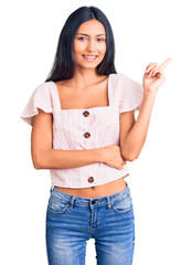 Wall Mural - Young beautiful latin girl wearing casual clothes smiling happy pointing with hand and finger to the side