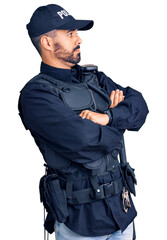 Poster - Young hispanic man wearing police uniform looking to the side with arms crossed convinced and confident