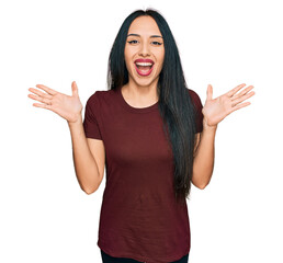 Wall Mural - Young hispanic girl wearing casual t shirt celebrating crazy and amazed for success with arms raised and open eyes screaming excited. winner concept